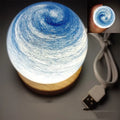 Modern planet-themed USB night light with dimming on a base, showing multiple colour options.