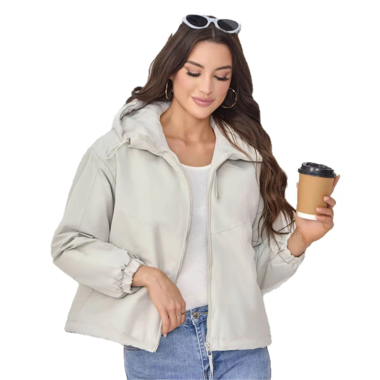 A woman wearing a loose-fitting grey hooded shell jacket with long sleeves, showing the front zip closure.