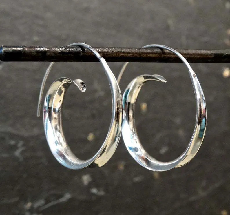 Gold alloy geometric round spiral leaf ear studs with electroplated finish on white background