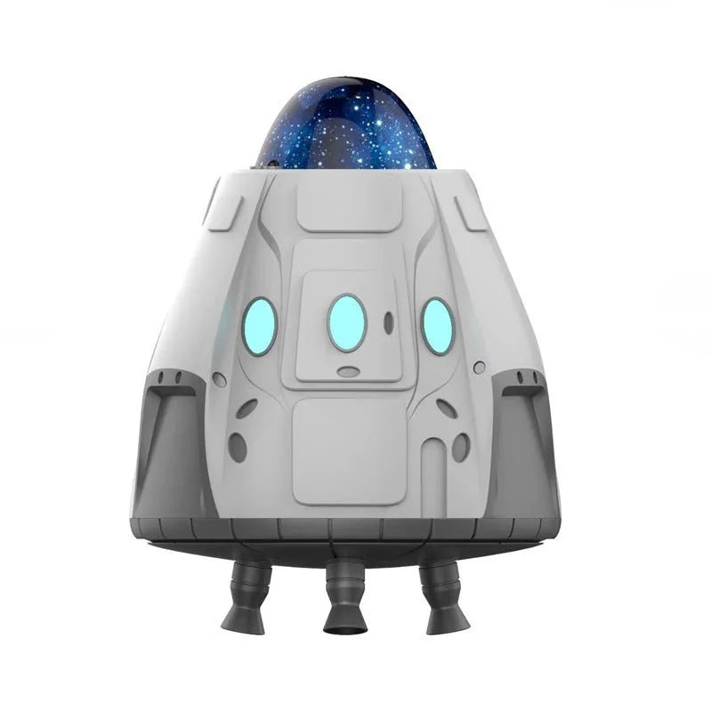 White space capsule shaped Bluetooth Northern Lights ambience light with remote control on a dark surface.