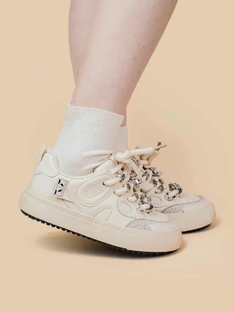 Casual women's white low-top sneakers with rubber sole and lace-up closure on a neutral background