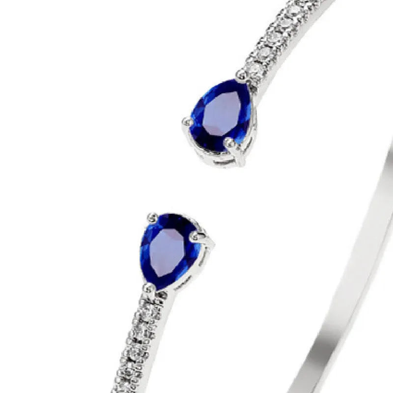 Copper bracelet with inlaid zircon decoration in blue colour on wrist