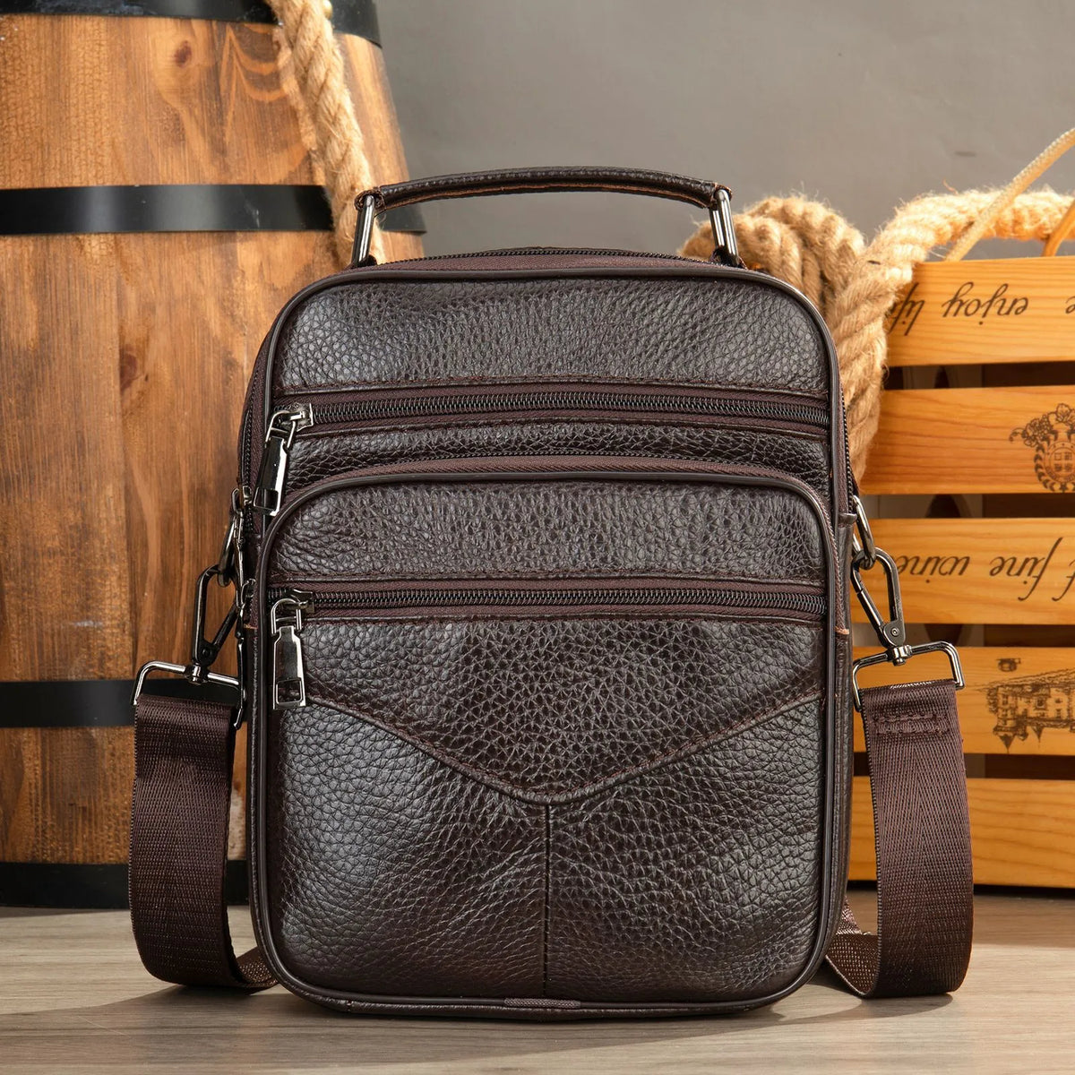 Men's top grain leather crossbody bag in brown with stitching detail and expandable side panels