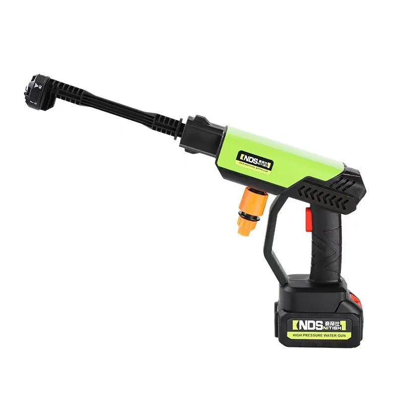 Green wireless high-pressure water gun with metal nozzle and multiple attachments on a table