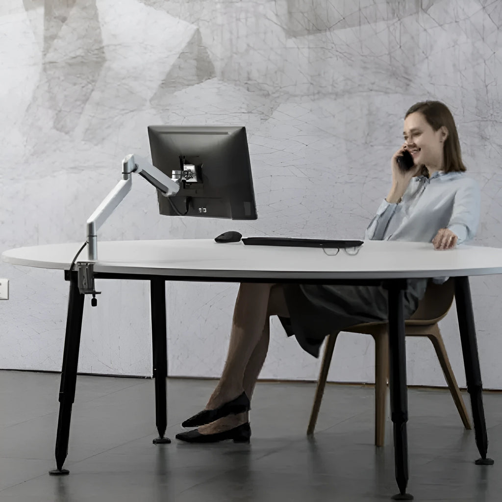 Silver aluminium laptop stand with adjustable air pressure arm holding a notebook above desktop