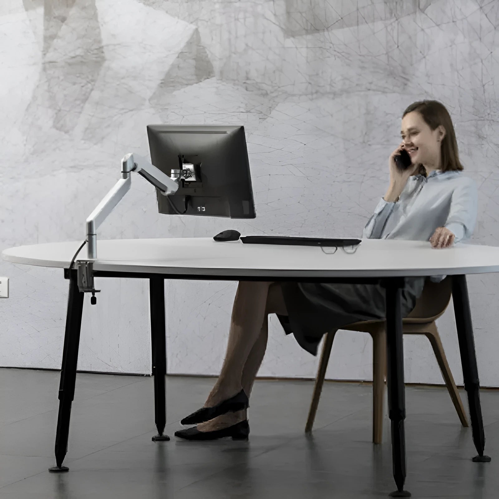 Silver aluminium laptop stand with adjustable air pressure arm holding a notebook above desktop