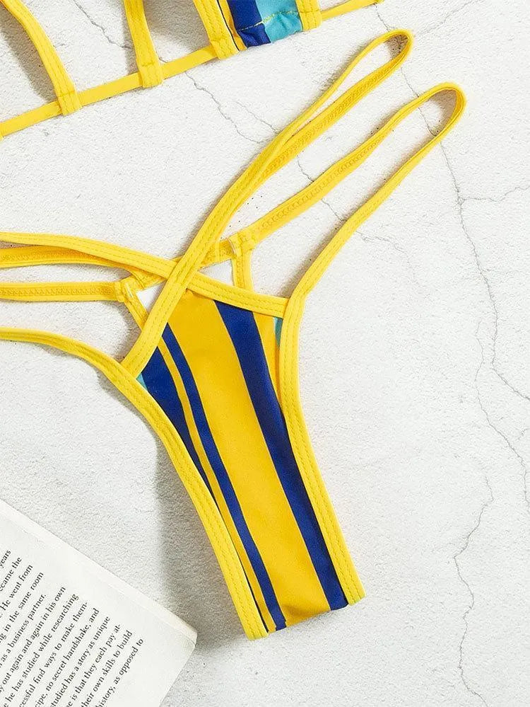 Yellow women's halter neck bikini with backless design and high-waist shorts on a neutral background.