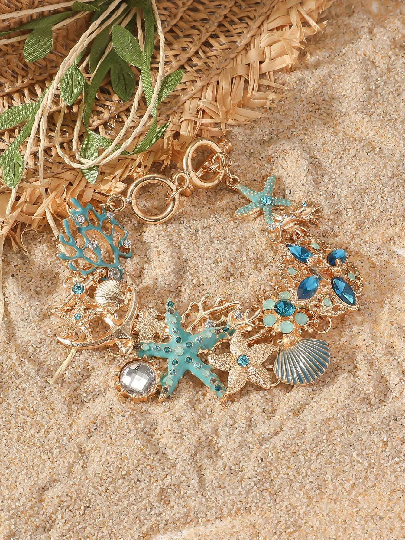Alloy rhinestone bracelet with boat anchor and starfish charm in turquoise, red, or blue.
