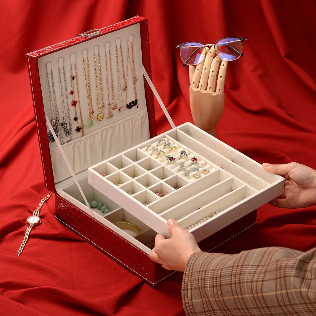 Green leather jewellery storage box with crocodile pattern, lock, and open double-layer interior.