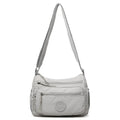 Water-repellent nylon crossbody cloth bag showing internal zipper compartments and shoulder strap