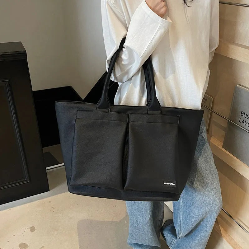 Lightweight expandable PU shoulder bag in black, shown with adjustable strap and sporty design.