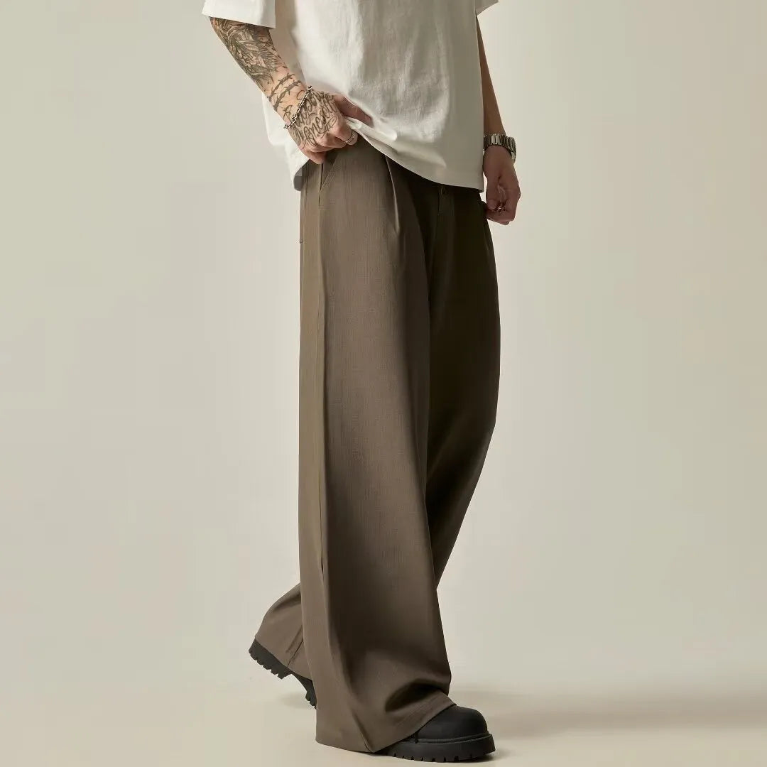 Men's black casual trousers with wide-leg design and button fly closure showing elastic waistband detail