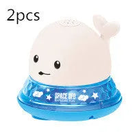 Automatic electric whale bath toy spraying water with LED lights on, floating in a baby bath.