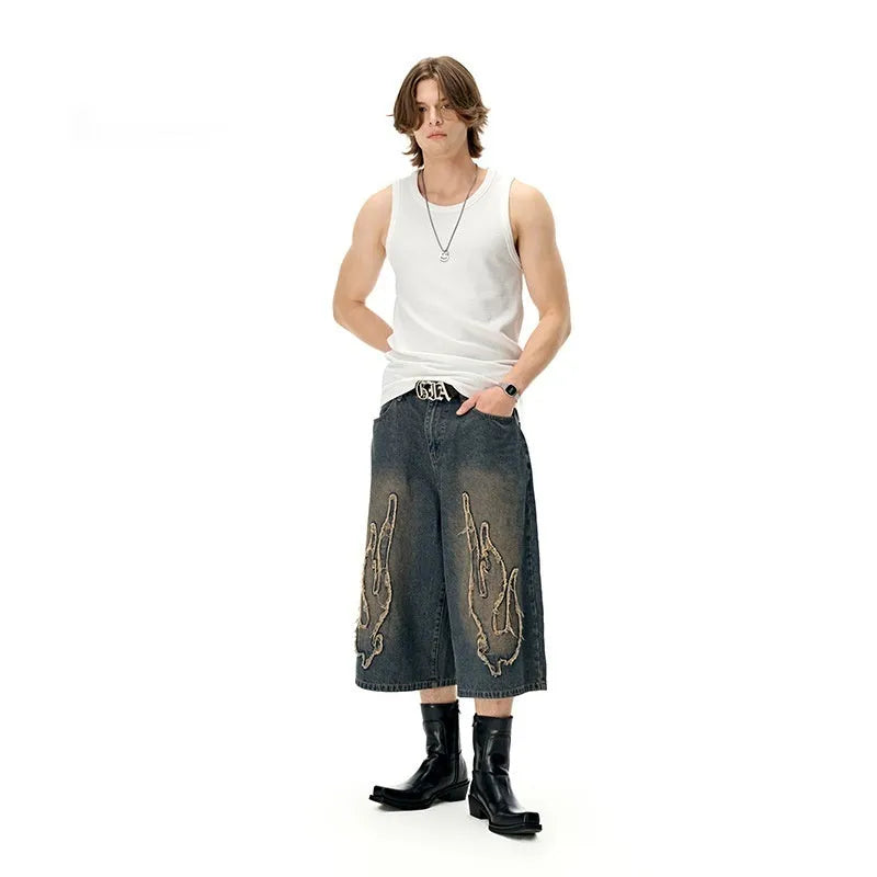 Men's black cropped denim shorts with flame embroidery patches on straight-leg cut