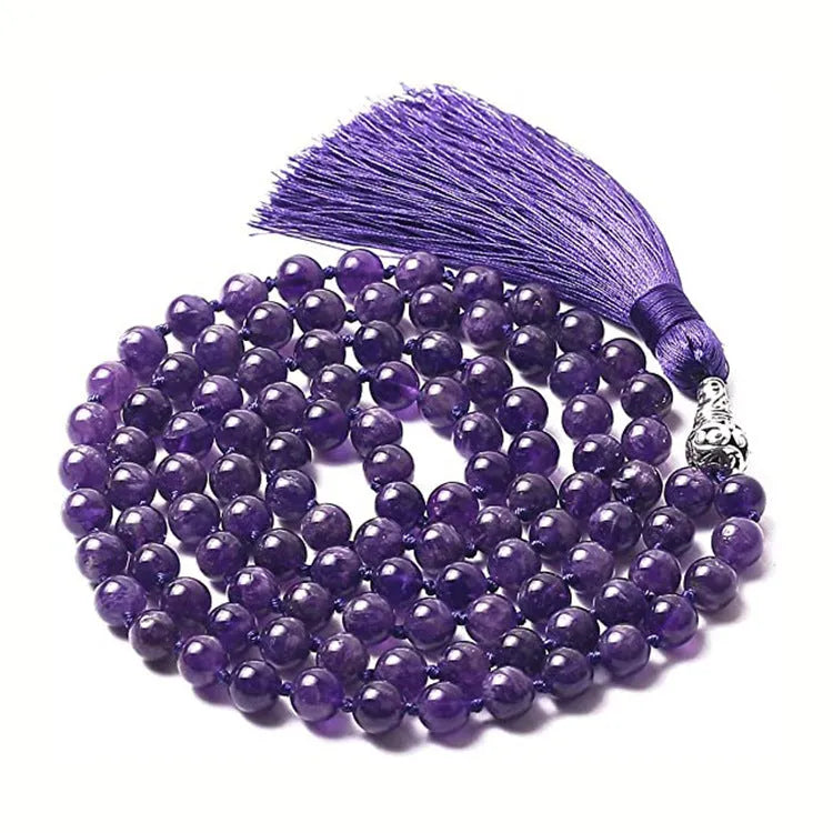 Long beaded agate and amethyst tassel necklace with geometric pendant on a neutral background.