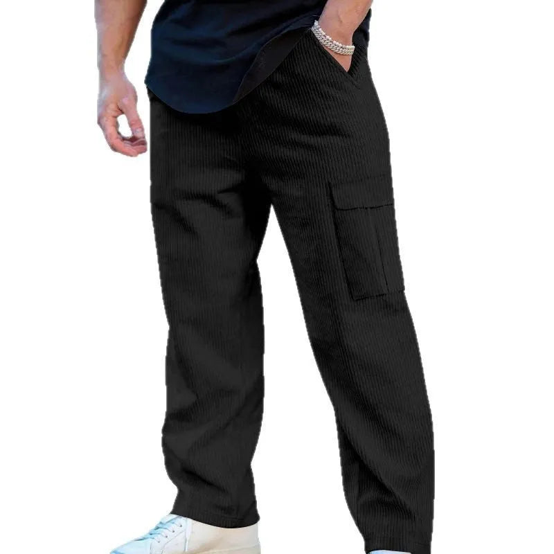 Man wearing loose-fitting straight-leg corduroy cargo trousers in navy blue with a drawstring waist.