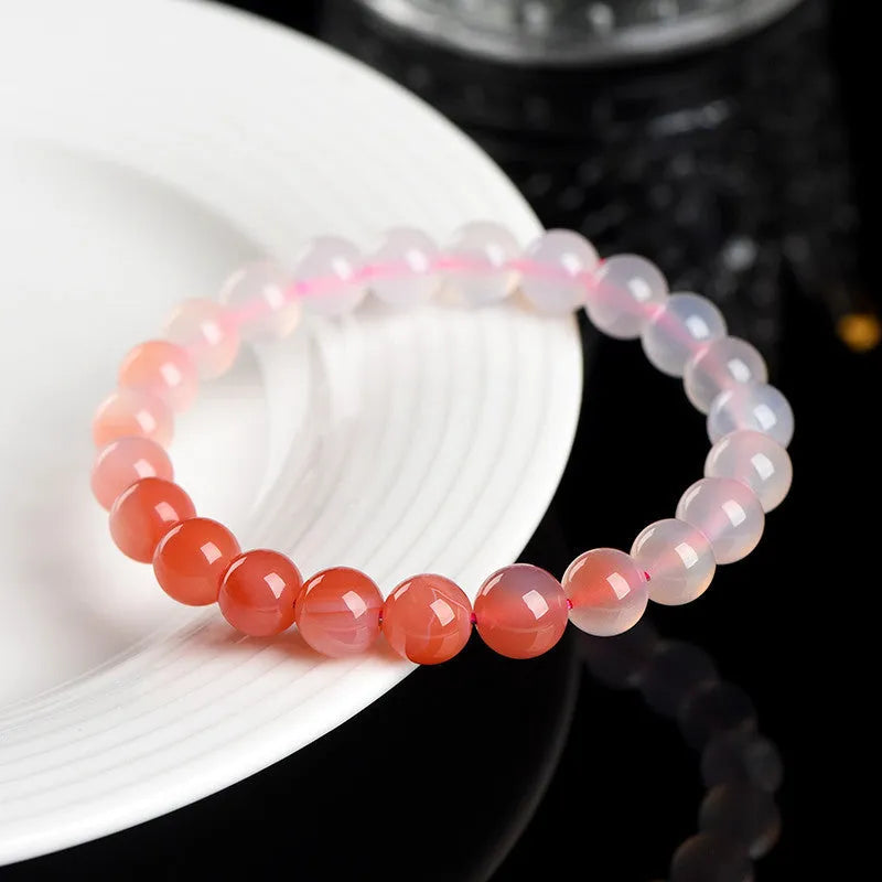 Natural gradient Yanyuan agate bracelet with geometric beads on a white background.