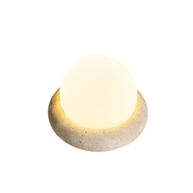 Cream coloured bedside night lamp with remote control on wooden table