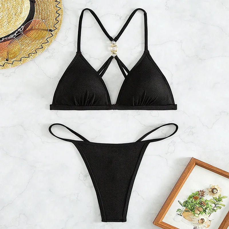 Black women's hollow backless triangle bikini top with high-waisted trousers on a mannequin