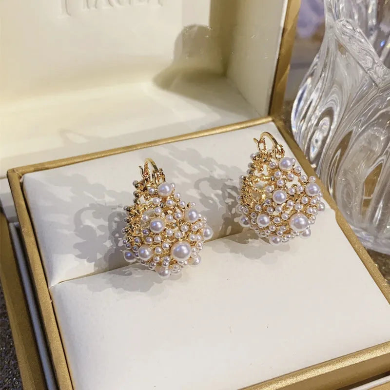 Women's gold copper earrings with floral basket design featuring small beads and pearl inlay detailing