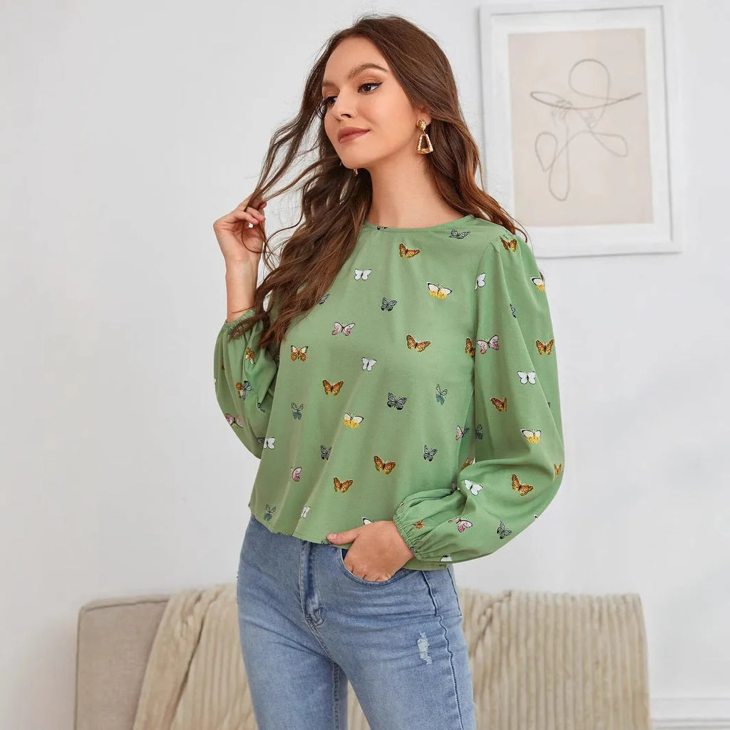 Green women's long sleeve shirt with butterfly print, showing loose fit and button front.