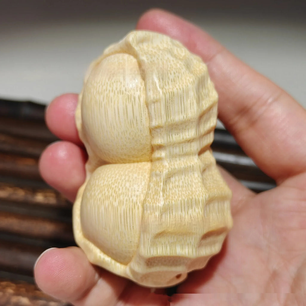 Modern minimalist solid bamboo carving peanut ornament on a neutral background.