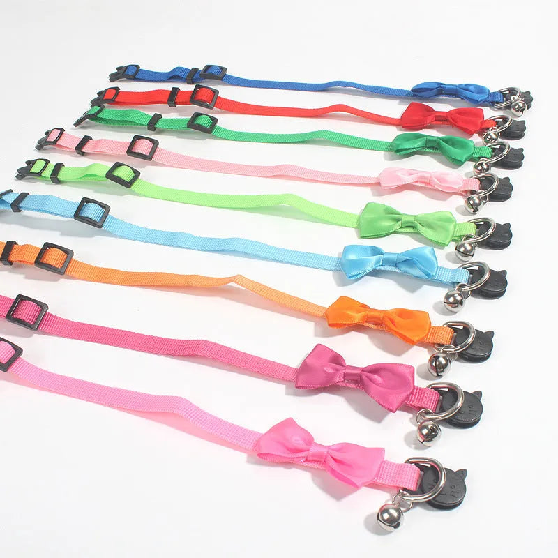 Adjustable nylon cat collar with decorative bow and bell in striped cartoon pattern, multiple colour options shown