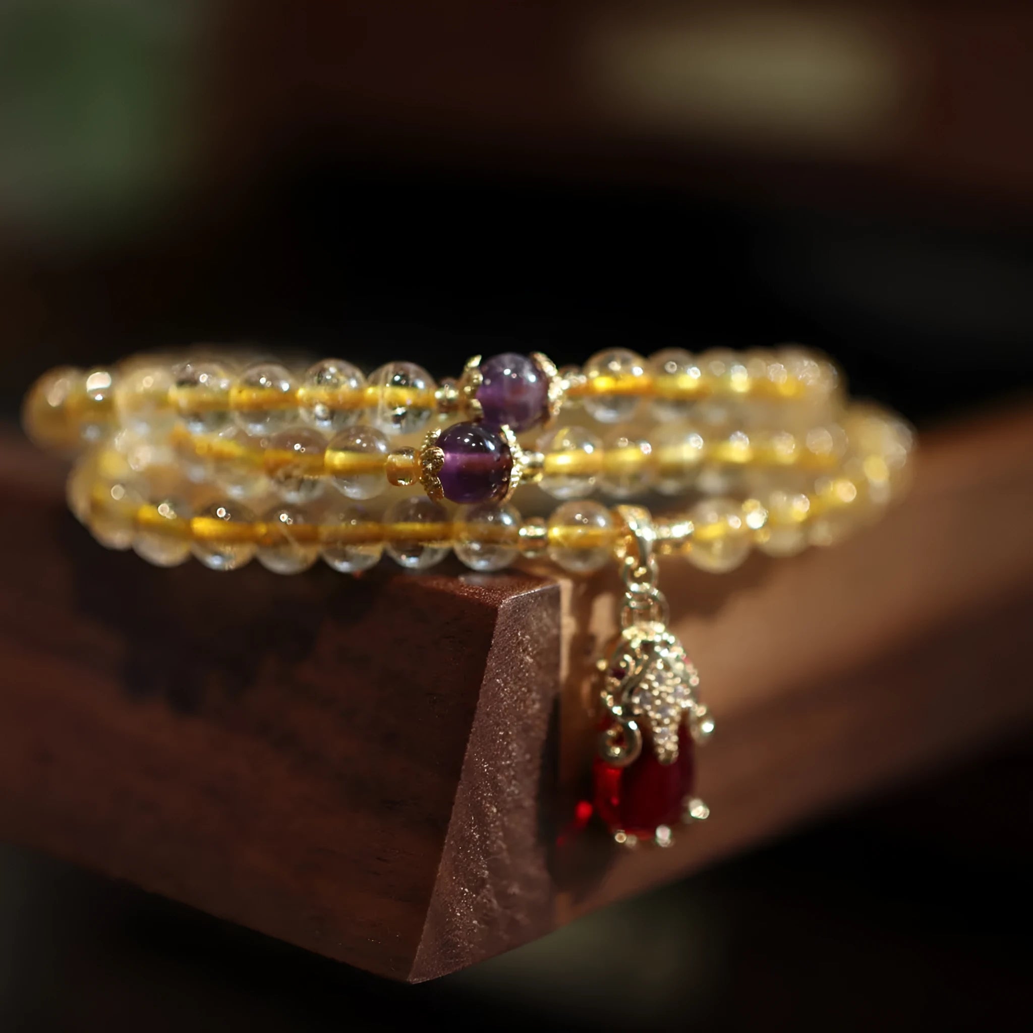 Gold rutilated quartz bracelet with three circles design and hanging chopsticks on wrist