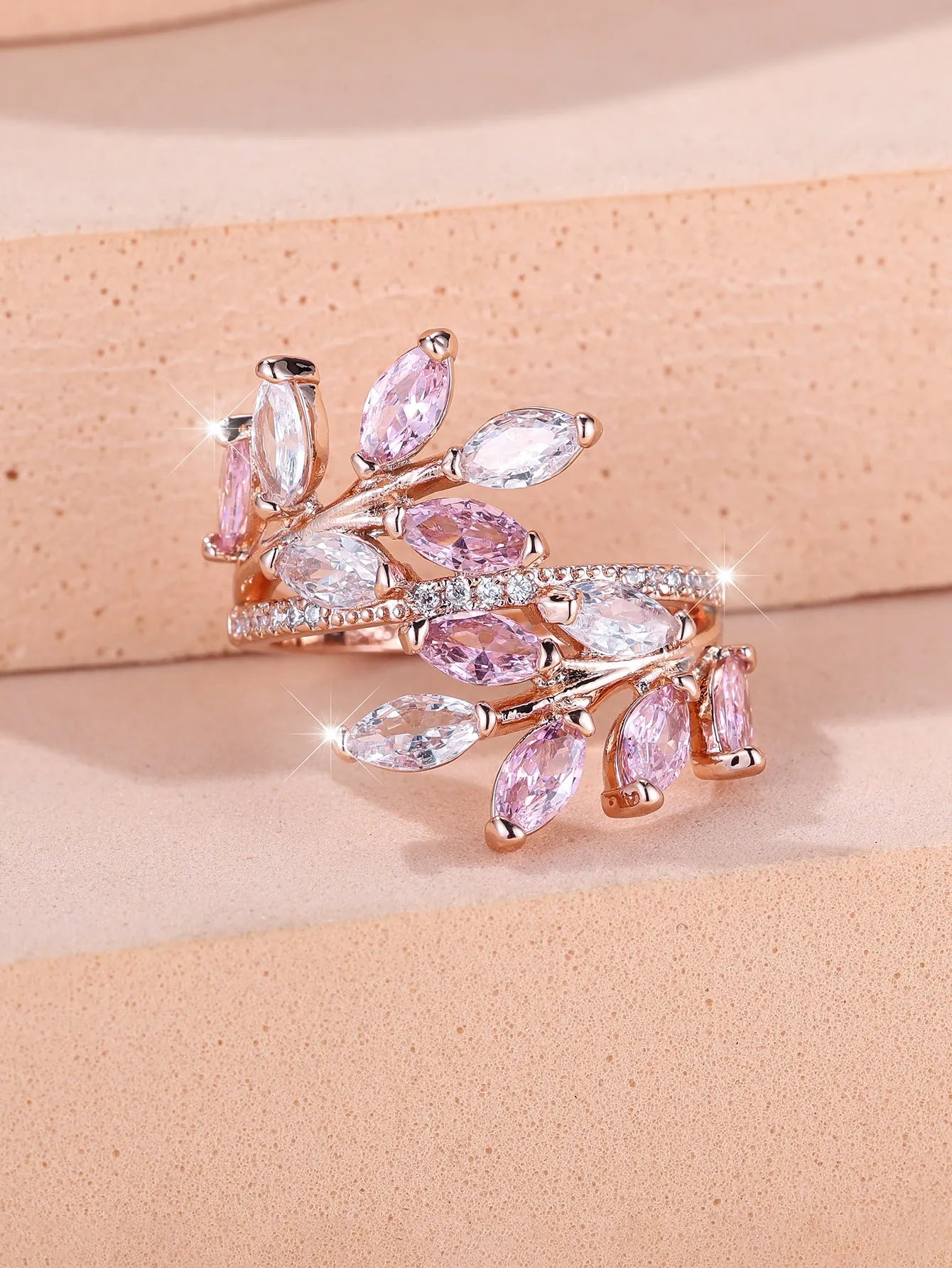 Adjustable leaf ring with horse eye zircon stone in rose gold finish on wooden background