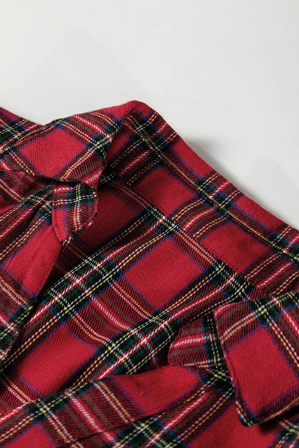 Red and black plaid women's mini dress with a shirt collar, long sleeves, and a ruffled hem.