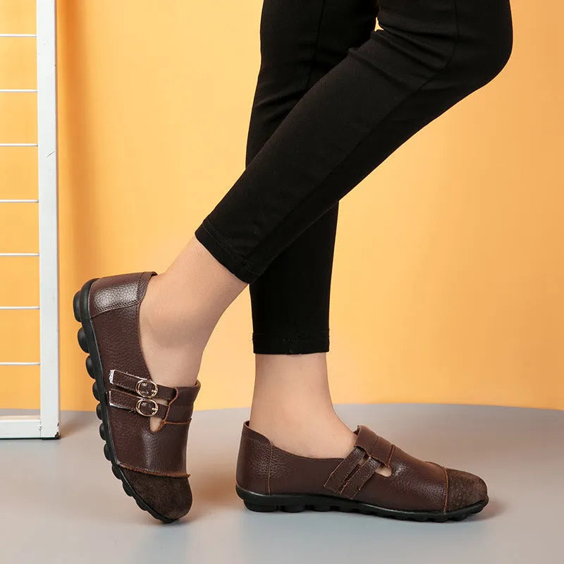 Casual low-top leather flat shoes with a round toe and a single Velcro strap closure.