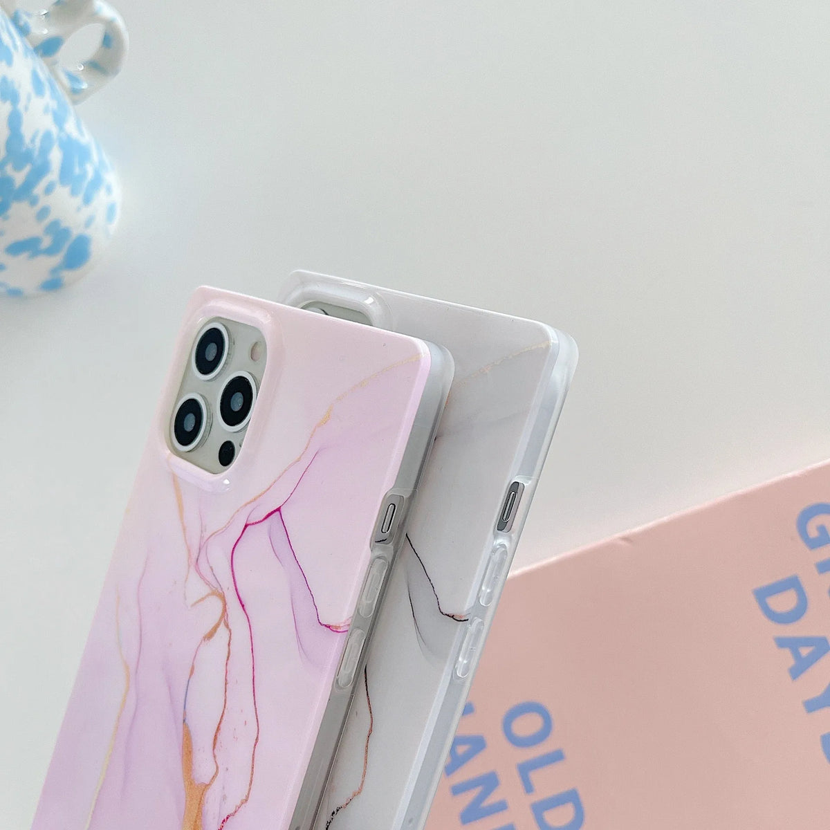 Square gilt marble iPhone case in TPU and silicone with straight edge and IMD print, shown in marble colourways