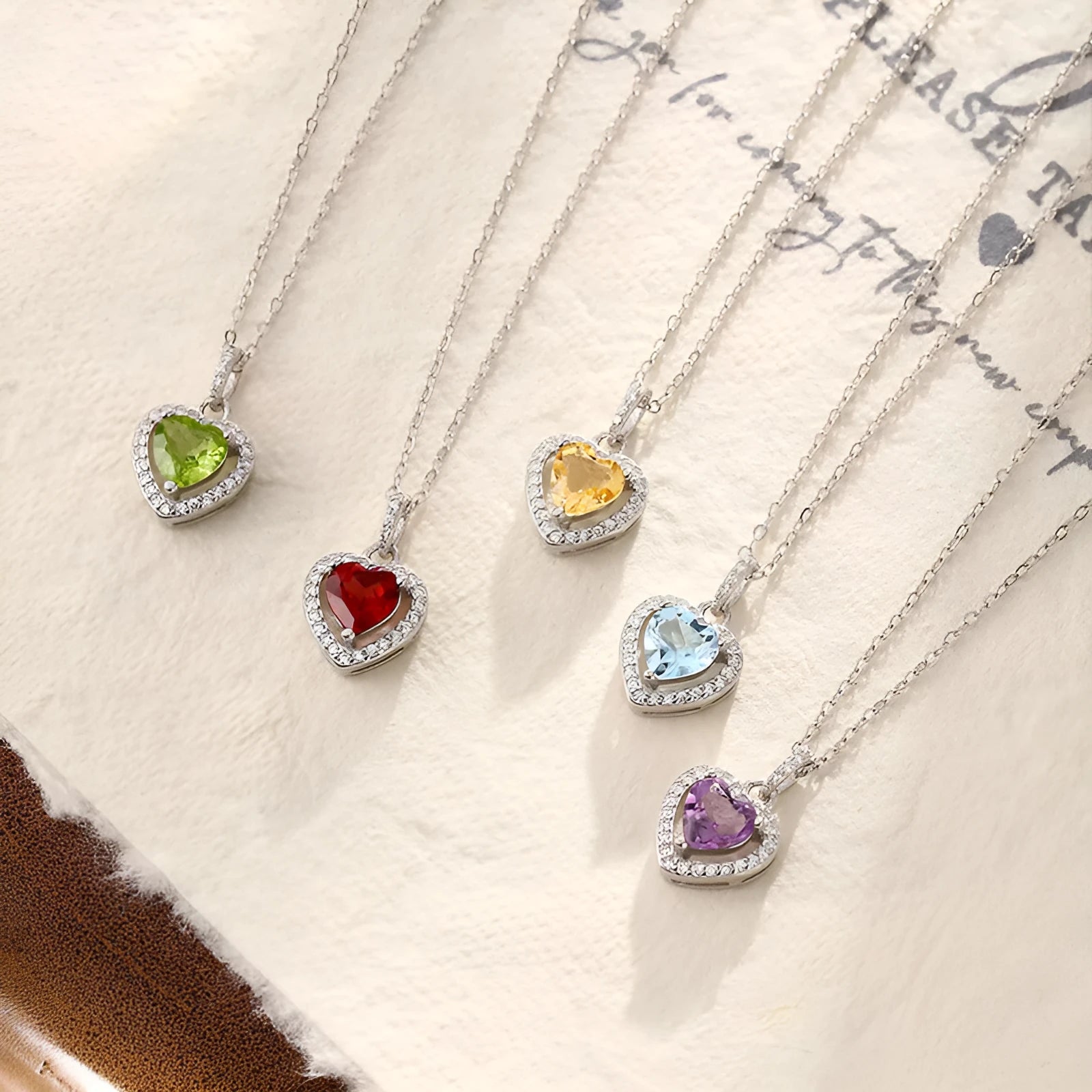 Sterling silver heart pendant necklace with inlaid gemstone on a cross chain for women.