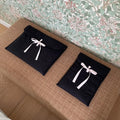 Black and white quilted women's laptop bag with striped pattern and a ballet-style bow.