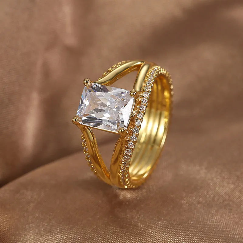 Gold-coloured geometric women's ring with a square zircon stone, shown in sizes 6 to 9.