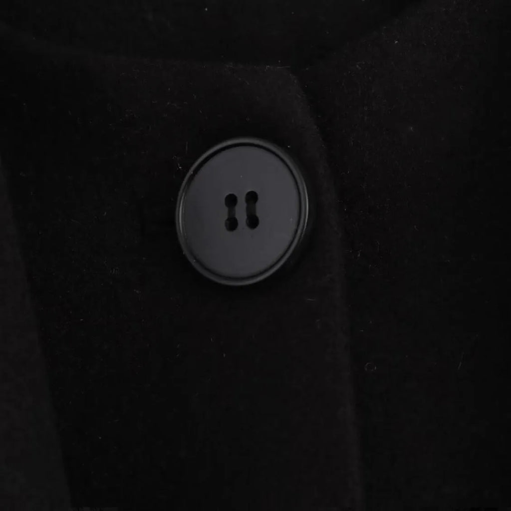 Women's long black overcoat with artificial fur collar, showing extended length and street fashion style.
