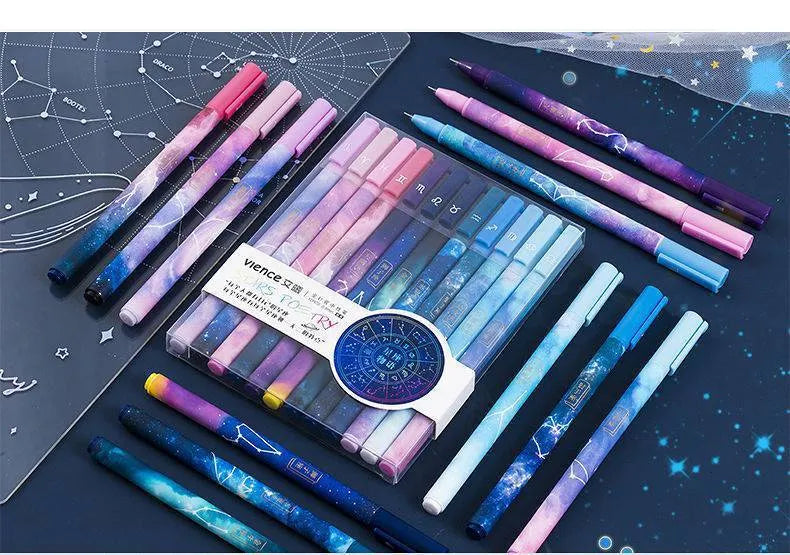 Twelve constellation ballpoint pens with zodiac designs on a light background