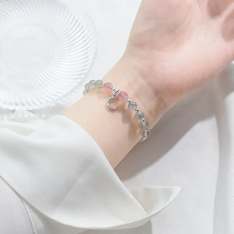 Handmade adjustable moonstone bracelet with crescent moon charm and crystal pendant on wrist