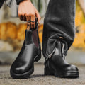 Vintage brown Chelsea boots with frosted PU upper and round toe on wooden floor