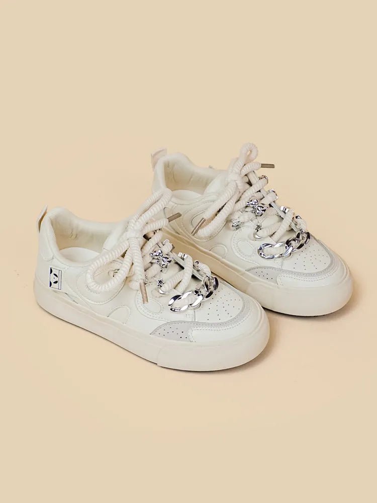 Casual women's white low-top sneakers with rubber sole and lace-up closure on a neutral background