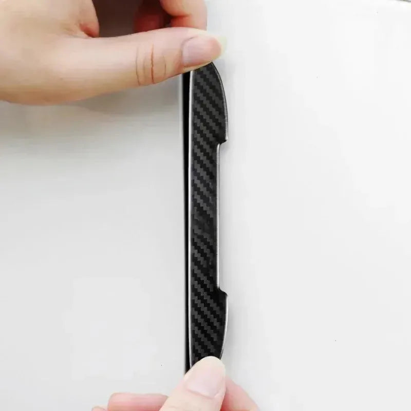 Black carbon fibre texture car door edge protector strips laid out flat.