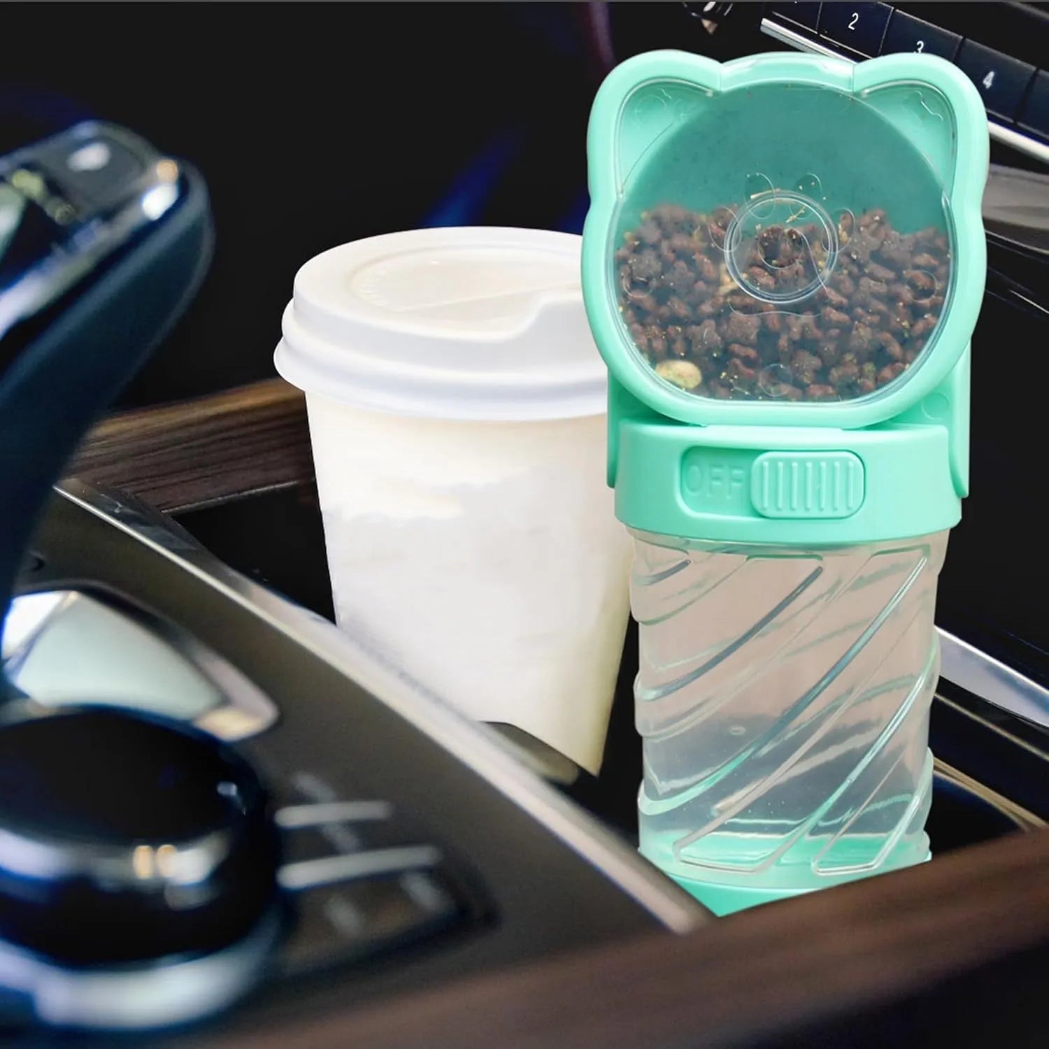 Green 3-in-1 portable pet water bottle with food container and waste bag dispenser held by hand strap