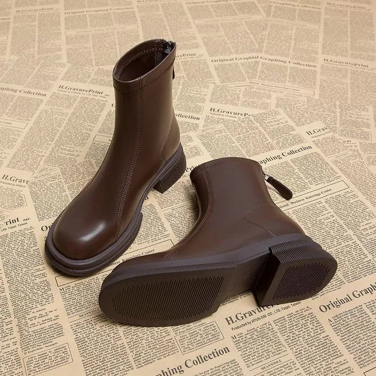 Women's black flat heel ankle boots with round toe and rear zipper on a rubber sole.