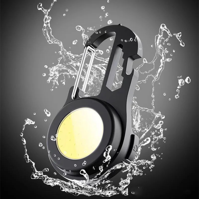 Black 6-in-1 multi-functional mini keychain lamp with COB light and magnetic base on metal surface
