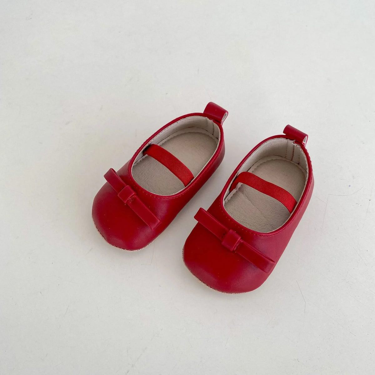 Baby girls' low top shoes with PU upper, rubber non-slip sole, bow detail, and elastic band, in black, white, chestnut brown, or red