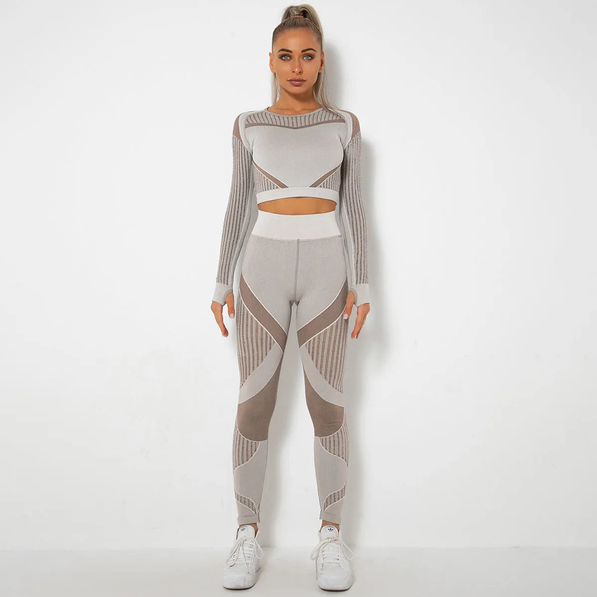 Woman wearing a seamless long-sleeved yoga suit in a neutral colour, demonstrating a stretch pose.