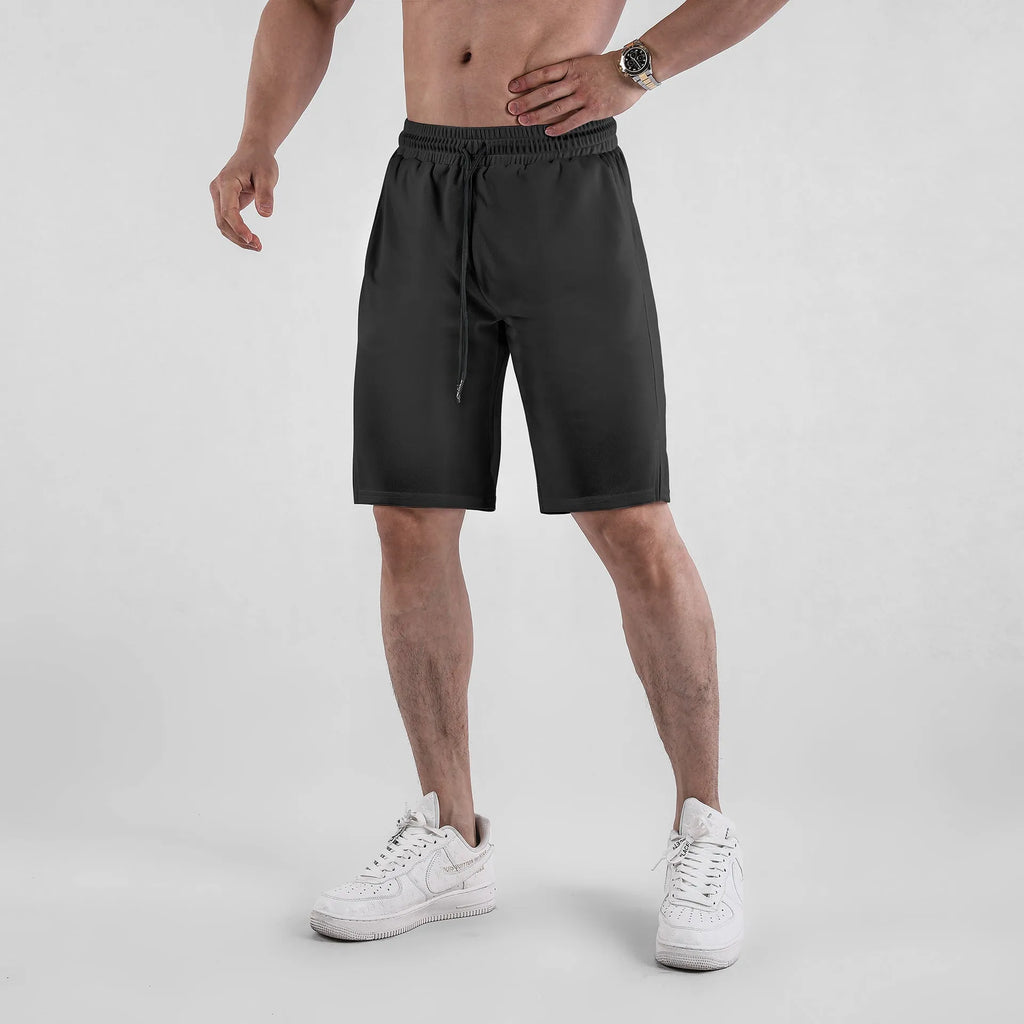 Men's black quick-drying mesh shorts in a loose capri length with elastic waistband.