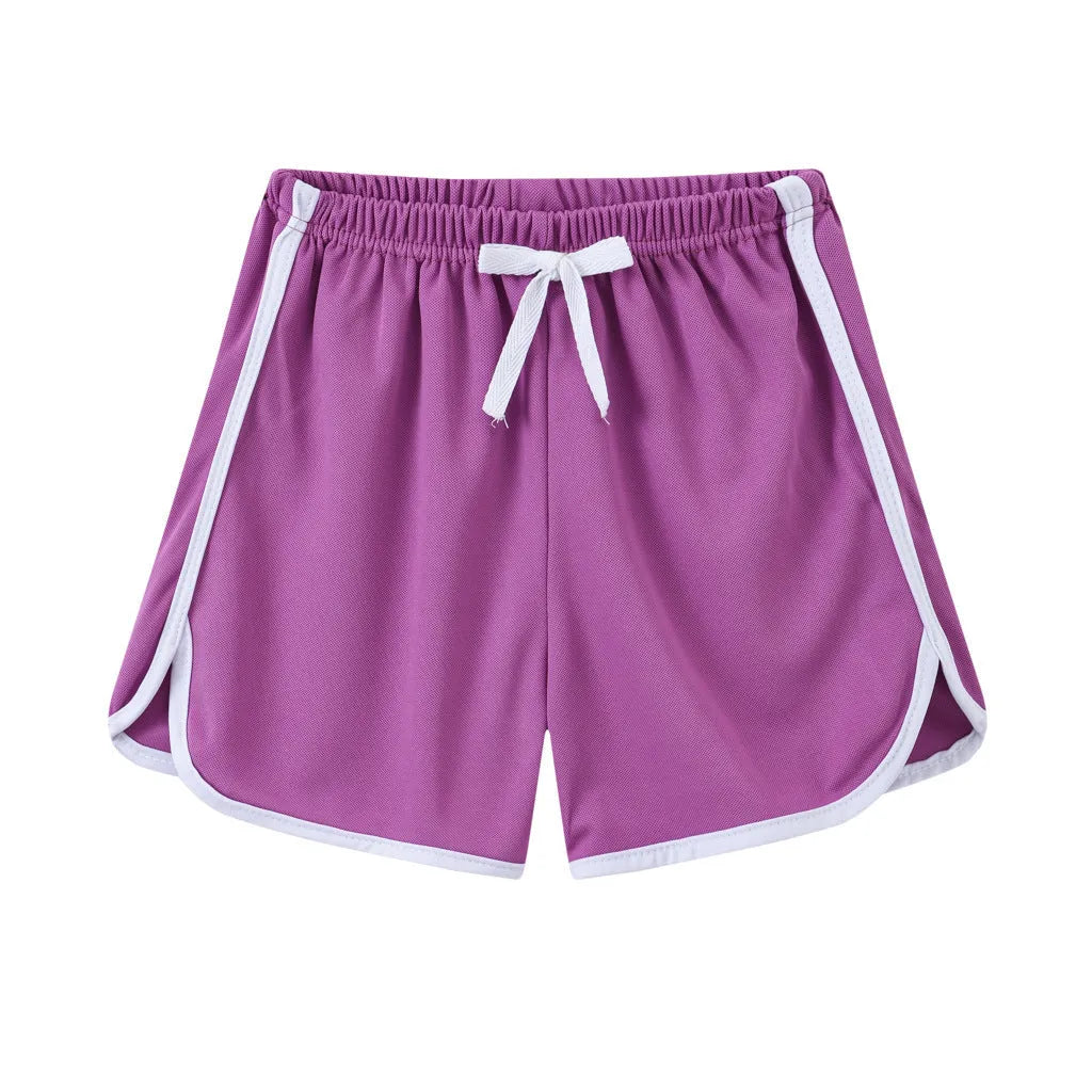 Children's polyester holiday shorts in multiple colours and patterns including stripes, leopard print, and pineapple design.
