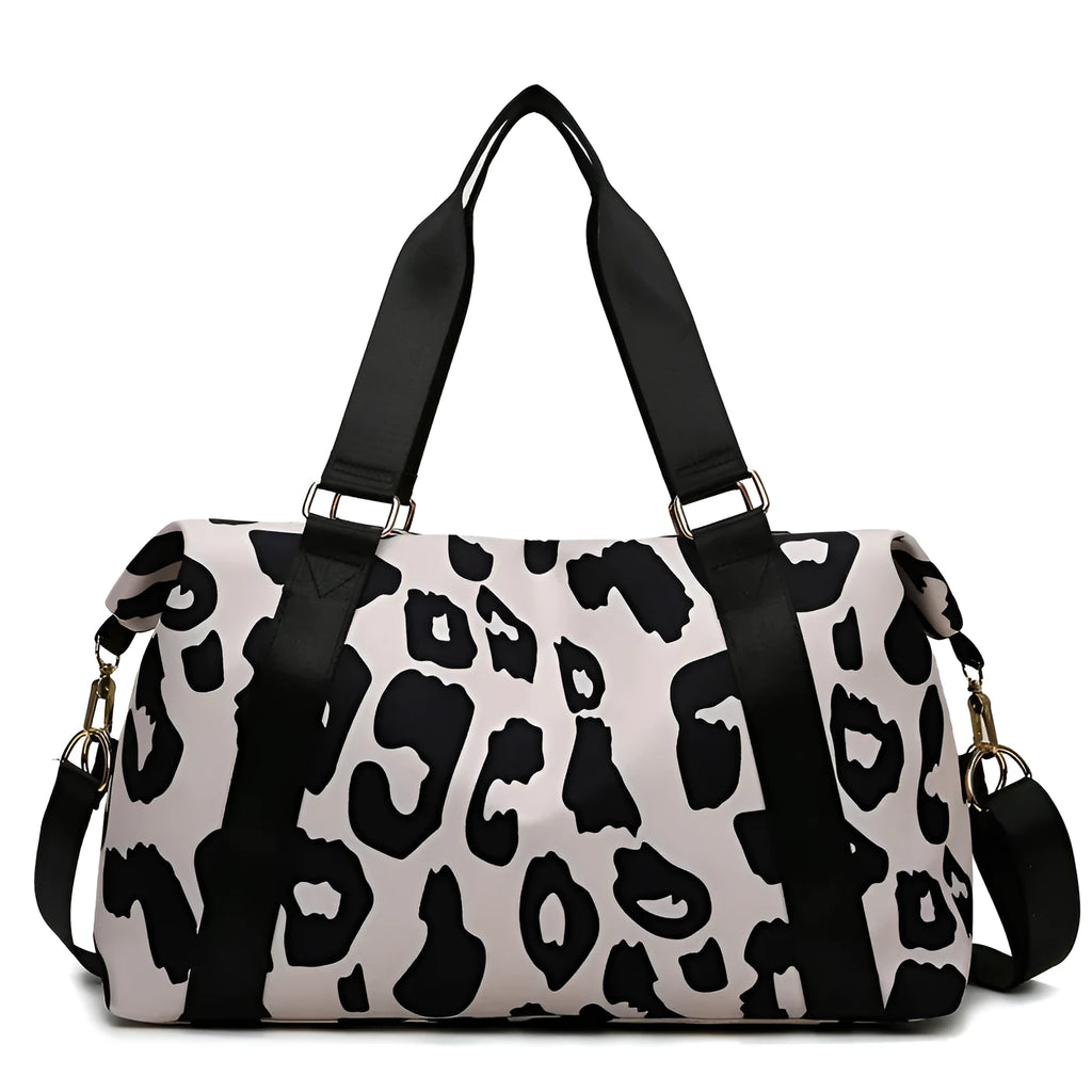 Women's large travel duffel bag with cow pattern, black, showing zippered main compartment and soft handle