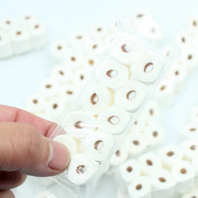Miniature simulated toilet paper roll model made from paper for dollhouse and children's pretend play.